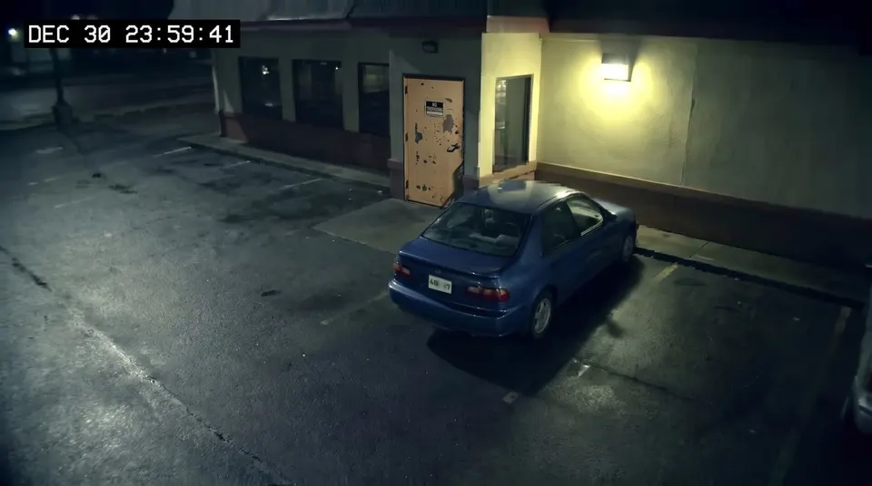 A blue sedan by the diner back door